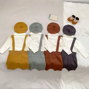 Flat lay of knit baby three-piece sets in four colors with sweaters, rompers and hats