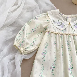 Detail of baby floral bodysuit with purple flower embroidery and lace Peter Pan collar