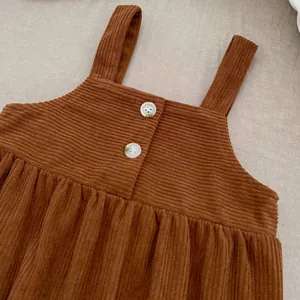 Detail der warmbraunen Baby-Cordhose mit weißen Marmorknöpfen und sauberen Nähten