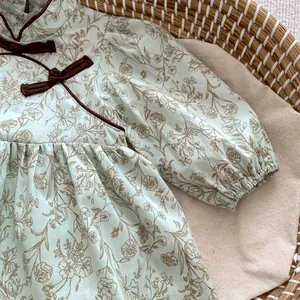 Detail of baby girl floral romper with Chinese frog button and lantern sleeves