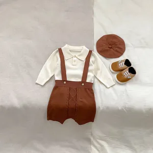Flat lay of knit baby set showing detailed beige long sleeve top and brown suspender shorts