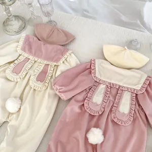 Flat lay of pink and beige baby rompers with rabbit ear collars and matching beret hats