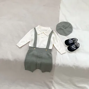 Close-up of sage green knitted overalls with diamond pattern and cream polo shirt