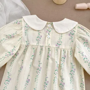 Detail of baby girl floral romper with white Peter Pan collar and rose pattern
