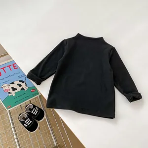 Detail of soft black infant long-sleeve tee with cozy knit texture and rolled cuffs