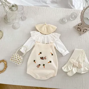 Vue à plat d'une barboteuse en maille pour bébé avec broderie carotte et accessoires