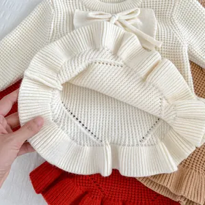 Detalle de suéter de punto con cuello de lazo y dobladillo con volantes de tela suave