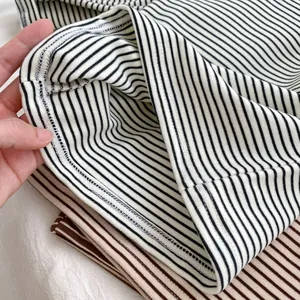 Detailed view of the double-needle hem stitching on striped cotton baby shirts