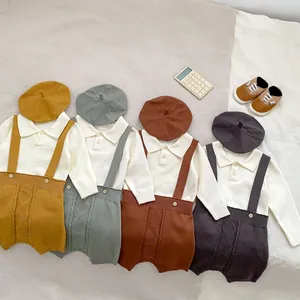 Flat lay of baby knitted three-piece set showing polo shirt, suspender shorts and beret