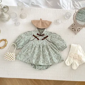 Flat lay of baby floral romper set with beret, wing socks and pearl handbag