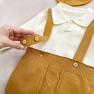 Close-up of baby knitted outfit showing cable knit pattern and texture on yellow suspenders