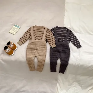 Detalle de conjunto tejido para bebé con suéter de rayas y peto de punto trenzado