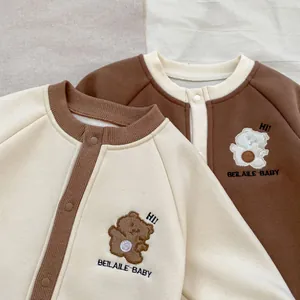 Détail de barboteuses pour bébé avec broderie ours et manches de couleur contrastée