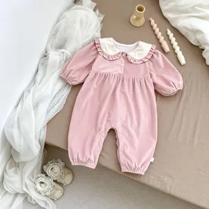 Detail of pink corduroy baby romper with white ruffle collar and matching lace shoes