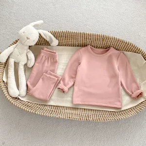 Detailed view of baby thermal innerwear set in soft bean paste pink on a cozy cradle