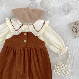 Detail der Babymädchen Bluse mit Rüschenkragen und Cord-Trägerkleid Set für Herbst