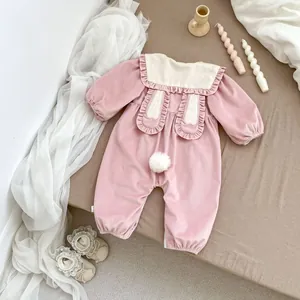 Detail of pink corduroy baby romper with rabbit ears collar and plush bunny tail