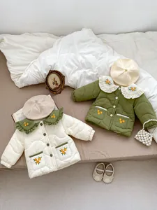 Detailed close-up of quilted floral embroidered children coats with wavy collar designs