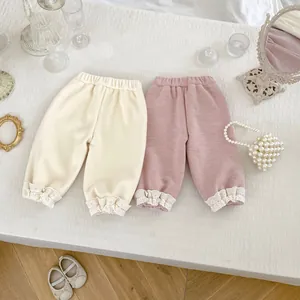 Detail view of toddler corduroy trousers featuring delicate white lace trim on the ankle cuffs