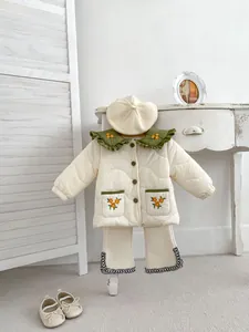 Detail of toddler girl winter outfit with green ruffled collar and floral embroidery