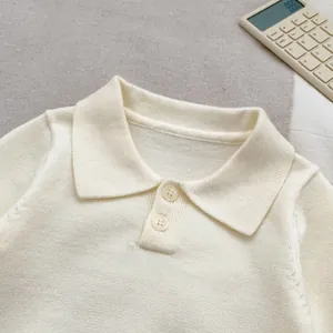 Close-up of the knitted polo shirt collar with buttons and soft cream cotton texture