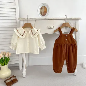 Details vom Baby-Herbstset mit besticktem Spitzenkragen und Kord-Latzhose für Mädchen