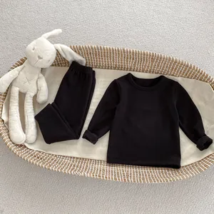 Close-up of black thermal thermal pajamas for babies neatly placed in a woven basket