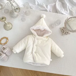 Détail du manteau d'hiver bébé avec doublure en peluche rose et pompon sur la capuche