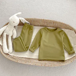 Olive green velvet-soft kids thermal loungewear set shown in a baby basket