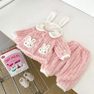 Detailed view of pink fleece pajamas with 3D bunny ears hood and matching plush shoes