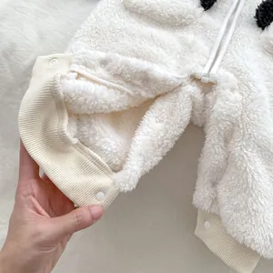 Dettaglio della tutina panda panna con texture in pile e chiusura con bottoni a pressione