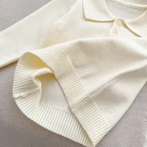 Close-up of knit polo shirt with lapel collar and buttons in cream white color