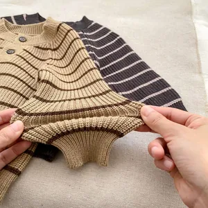 Detalle de los puños elásticos y la textura de rayas en el conjunto de punto para bebé