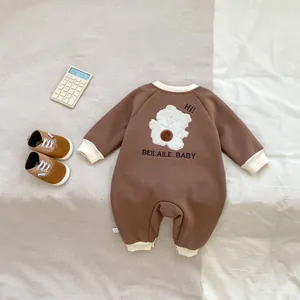 Détail de la barboteuse marron pour bébé avec broderie ours et finitions côtelées