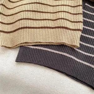 Primer plano del suéter de punto a rayas para bebé mostrando la textura acanalada
