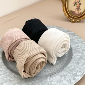 Texture côtelée détaillée de leggings en tricot pour bébé en rose, noir, blanc et beige