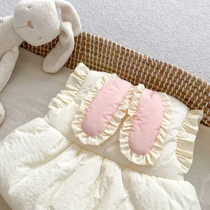 Détail du gilet bébé avec oreilles de lapin roses mignonnes et bordure en dentelle
