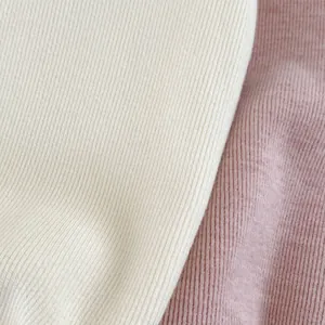 Detailed macro view of fine knit ribbed fabric texture in cream and light pink colors