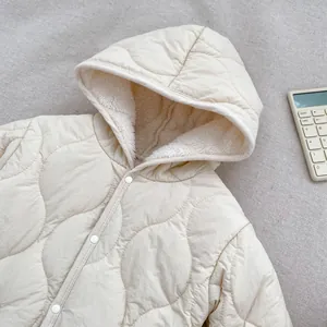 Dettaglio tutina neonato trapuntata con cappuccio, cuciture a onda e calda fodera in pile