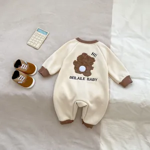 Détail de la grenouillère bébé beige avec broderie ours mignonne et bords côtelés