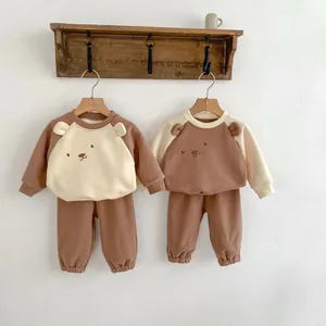 Détail de l'ensemble sweat en polaire ours avec oreilles 3D et pantalon sur cintre en bois