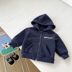 Detail of navy fleece hoodie for boys featuring white KEEP GOING letter print and rib cuffs