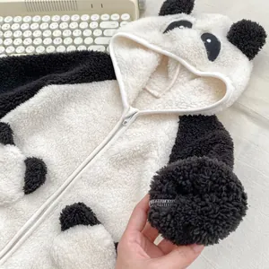 Dettaglio della tutina a panda per neonati con calda texture in pile e cappuccio