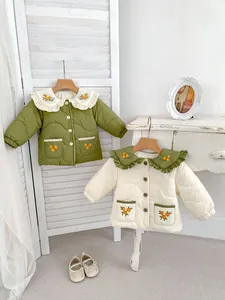 Detail of girls quilted jackets featuring floral embroidery and ruffle collars