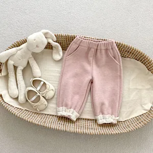 Detailed close-up of pink corduroy toddler pants with delicate lace trim at the ankles
