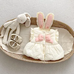 Détail du gilet bébé avec oreilles de lapin, nœud rose et bords à volants doux