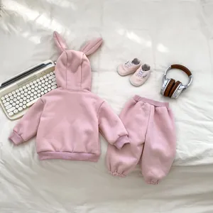 Detailed flat lay of pink infant tracksuit featuring rabbit ear hood and matching pants