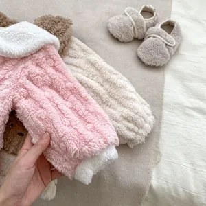 Close-up of soft coral fleece baby winter pajamas with non-slip shoes and warm texture