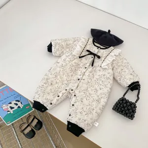 Detailed view of floral baby padded jumpsuit with lace frills and black bow detail