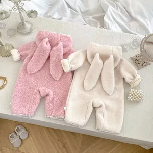 Detail of plush baby rompers with rabbit ears and floral trim on warm fleece fabric